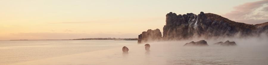 Couple taking a dip at the Sky Lagoon in Reykjavik, Iceland.
