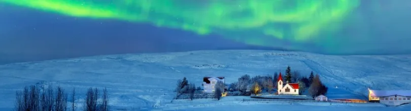 Northern Lights above a snowy landscape in Iceland.